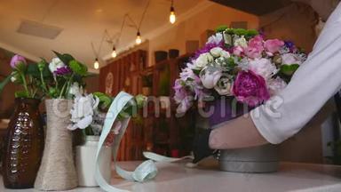 花店花店花店布置现代花束，织带做蝴蝶结，年轻英俊的花店花店工作